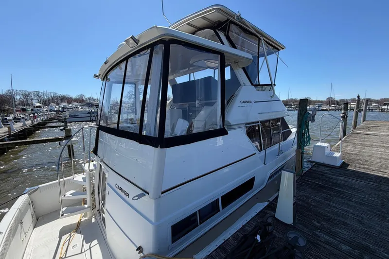 Slide: The Image of 1997 Carver 400 Cockpit Motor Yacht docked at marina under clear blue sky. - 6