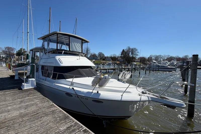 Slide: The Image of 1997 Carver 400 Cockpit Motor Yacht docked at a marina under clear blue skies. - 8