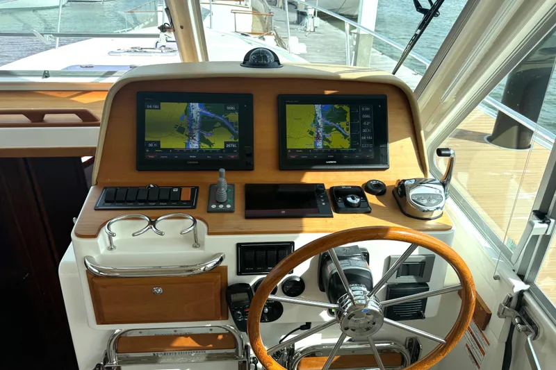 Slide: The Image of Helm of 2018 Back Cove 41 boat with navigation screens and wooden steering wheel. - 10