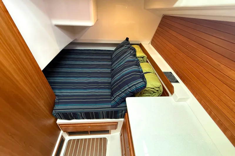 Slide: The Image of 2018 Back Cove 41 cabin interior with striped bedding and wooden paneling. - 19