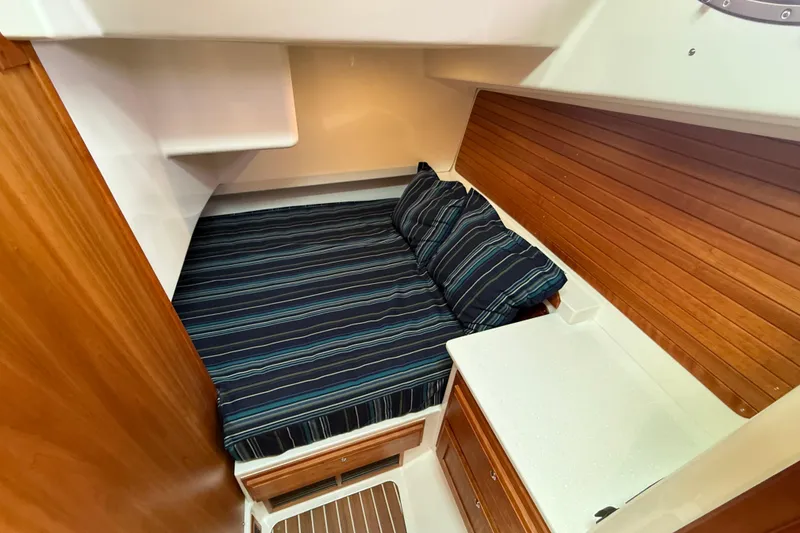 Slide: The Image of 2018 Back Cove 41 cabin interior with striped bedding and wooden accents. - 20