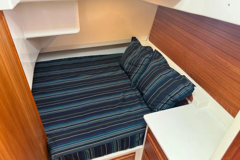 Slide: The Image of Cozy cabin interior of 2018 Back Cove 41 with striped bedding and wooden accents. - 21