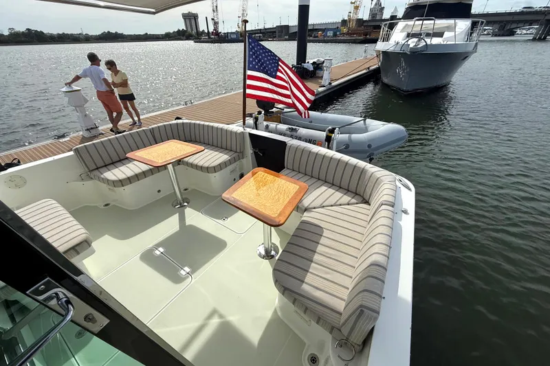 Slide: The Image of 2018 Back Cove 41 yacht with striped seating, docked by the water. - 3