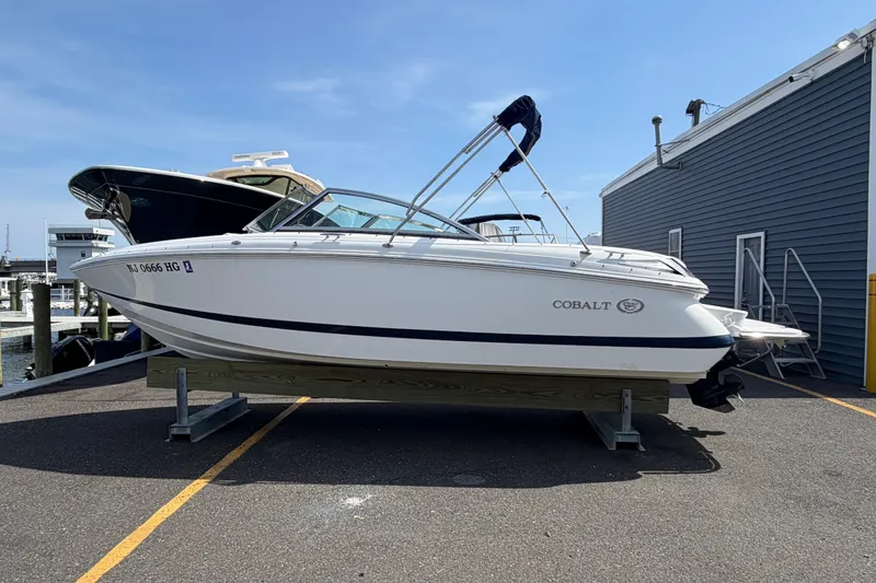 The Image of 2014 Cobalt 210 boat on display at a marina, clear sky background. - 0