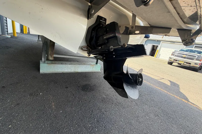 Slide: The Image of 2014 Cobalt 210 boat with MerCruiser outdrive, parked on asphalt near a garage. - 16