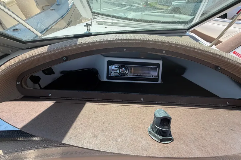 Slide: The Image of 2014 Cobalt 210 boat dashboard with stereo system and open compartment. - 18