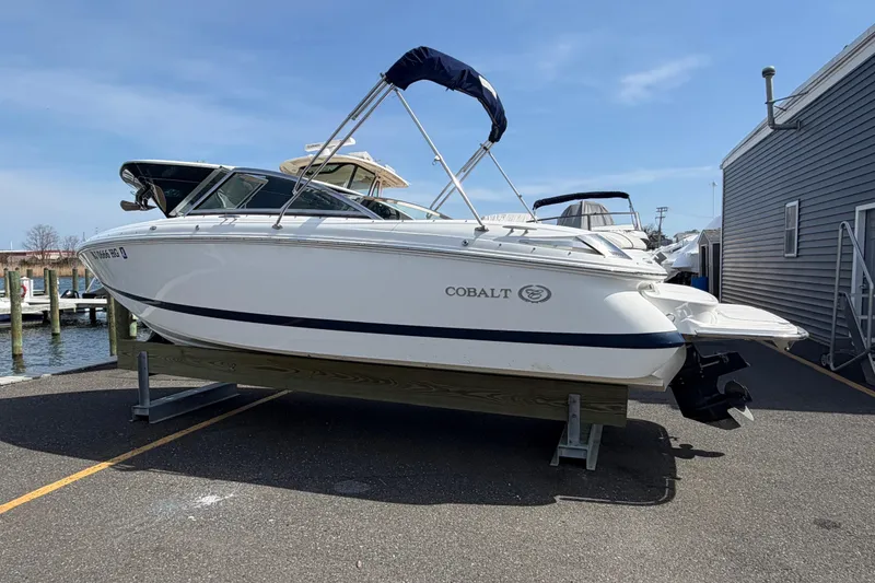 Slide: The Image of 2014 Cobalt 210 boat on a trailer at a marina, clear sky background. - 3