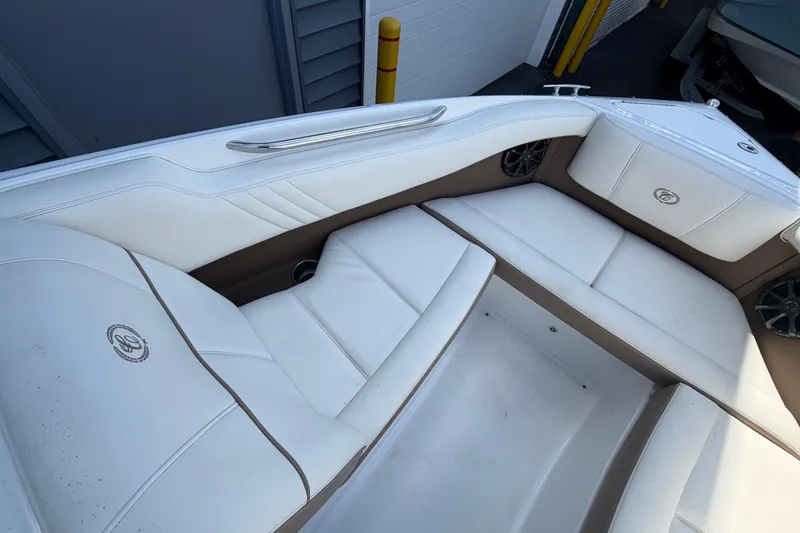 Slide: The Image of 2014 Cobalt 210 boat interior with white and brown seating, featuring sleek design and speakers. - 6