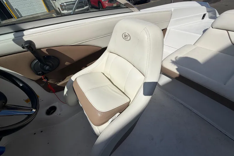 Slide: The Image of 2014 Cobalt 210 boat interior with white and beige seating, steering wheel, and controls. - 7