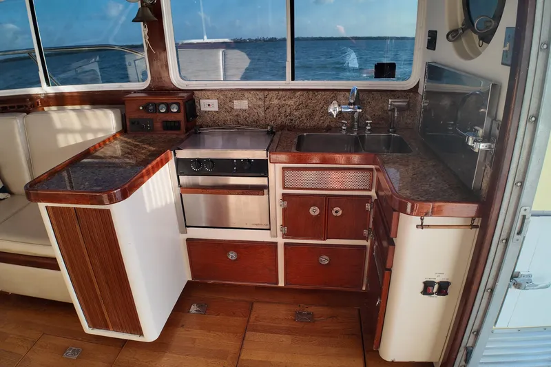 Slide: The Image of Compact kitchen area on a 1999 Anderson Downeast Aluminum Fast Trawler with wood and stainless steel finishes. - 10