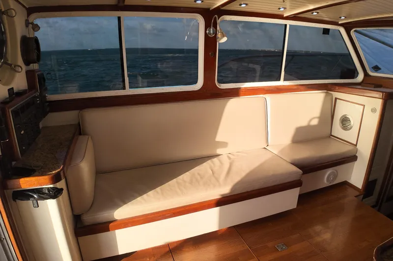Slide: The Image of Interior of 1999 Anderson Downeast Aluminum Fast Trawler with beige seating and ocean view. - 11