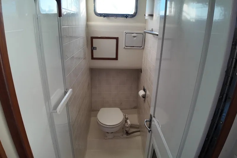 Slide: The Image of Bathroom interior of 1999 Anderson Downeast Aluminum Fast Trawler, featuring compact design and window. - 13