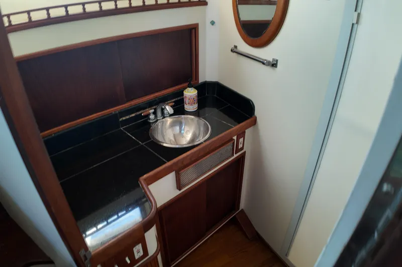 Slide: The Image of Compact bathroom sink area on 1999 Anderson Downeast Aluminum Fast Trawler, featuring wood accents. - 16