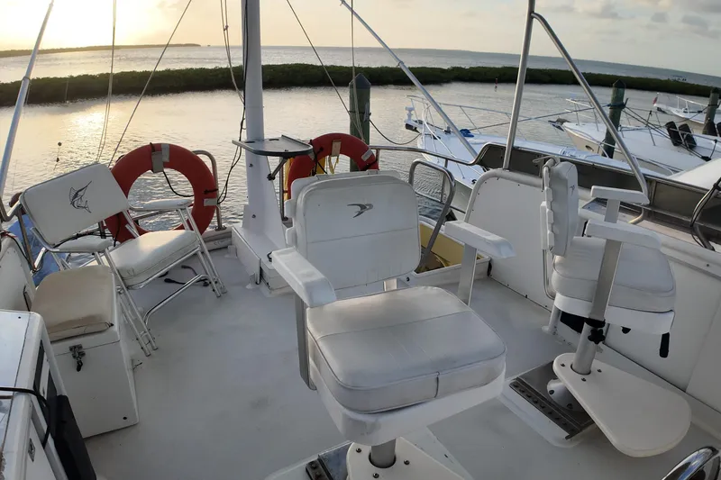 Slide: The Image of Deck of 1999 Anderson Downeast Aluminum Fast Trawler at sunset, featuring seating and life rings. - 24
