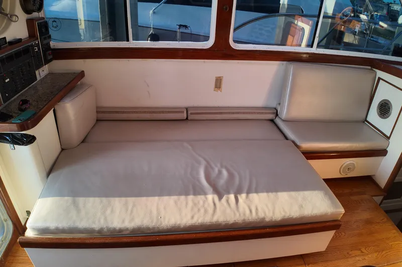 Slide: The Image of Interior seating area of a 1999 Anderson Downeast Aluminum Fast Trawler with cushioned benches. - 27