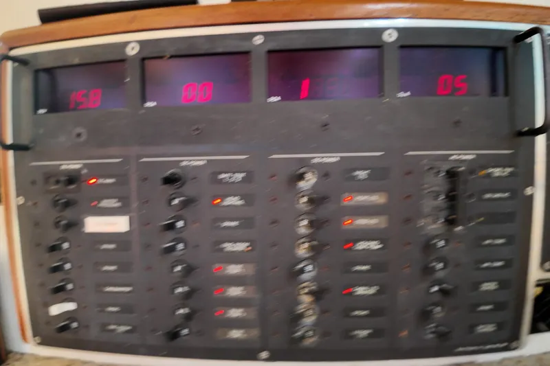 Slide: The Image of Control panel of a 1999 Anderson Downeast Aluminum Fast Trawler with digital displays and switches. - 33