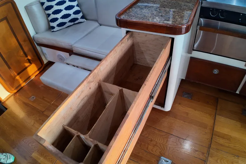 Slide: The Image of Interior of 1999 Anderson Downeast Trawler with open wooden drawer and seating area. - 46