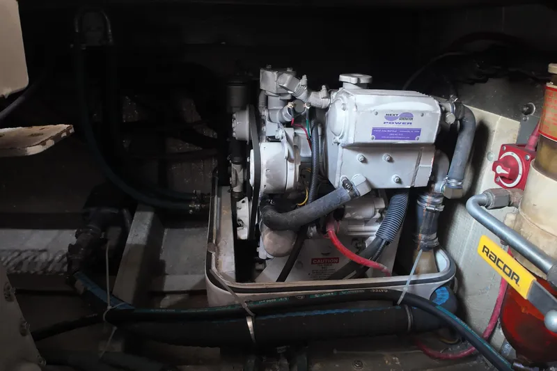 Slide: The Image of Engine room of 1999 Anderson Downeast Aluminum Fast Trawler, featuring mechanical components and hoses. - 50