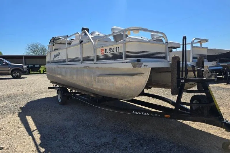 Slide: The Image of 2004 Bandit Pontoon boat on trailer in sunny outdoor setting. - 5