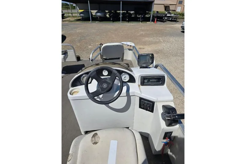 Slide: The Image of 2004 Bandit Pontoon boat dashboard with steering wheel and controls. - 6