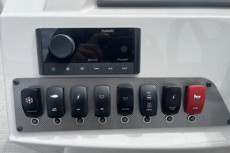 Slide: The Image of Control panel of 2024 Crest Classic 220 boat with switches and Fusion audio system. - 11
