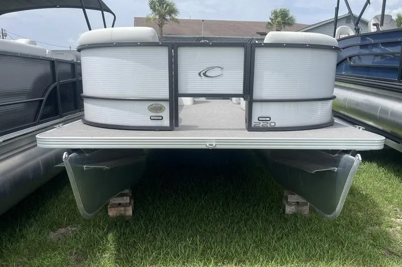 Slide: The Image of 2024 Crest Classic 220 pontoon boat displayed on grass. - 2