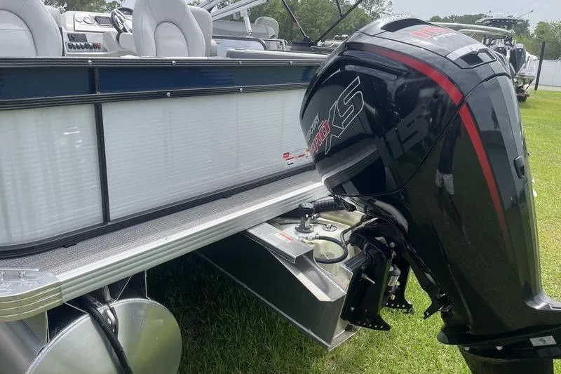 Slide: The Image of 2024 Crest Classic 220 pontoon boat with powerful outboard motor on grassy area. - 3