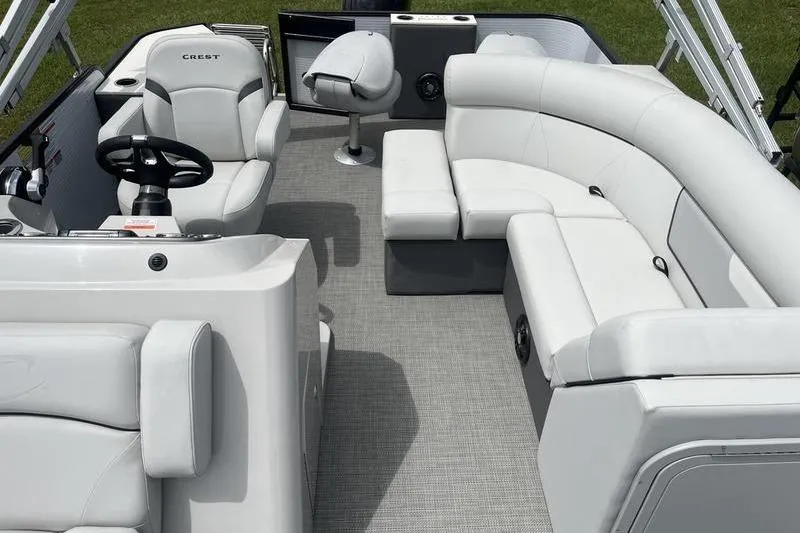 Slide: The Image of 2024 Crest Classic 220 boat interior with plush white seating and modern steering console. - 5