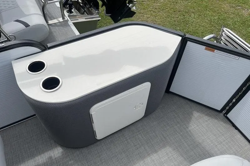 Slide: The Image of 2024 Crest Classic 220 boat interior with cup holders and storage compartment. - 6