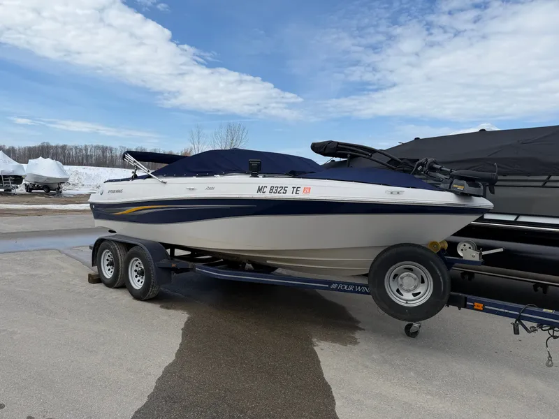 The Image of 2010 Four Winns H190 F/S boat on trailer outdoors. - 0