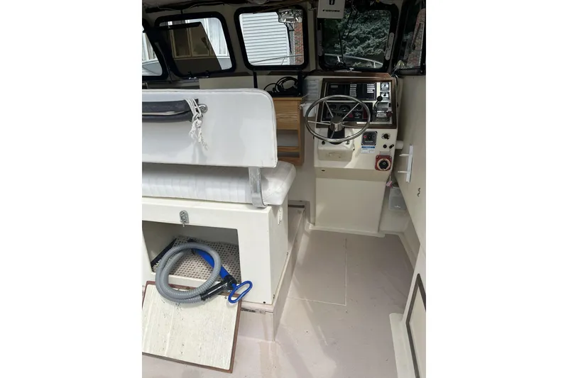 Slide: The Image of 1998 General Marine Custom Downeast boat interior with steering wheel and seating area. - 11