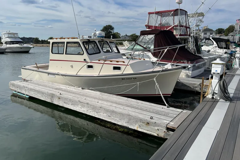 Slide: The Image of 1998 General Marine Custom Downeast boat docked at a marina on a sunny day. - 3