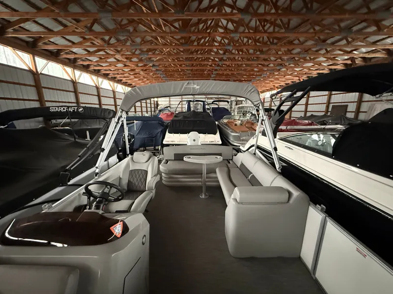 Slide: The Image of Interior view of a 2021 Bennington SSBXSD pontoon boat in a storage facility. - 17