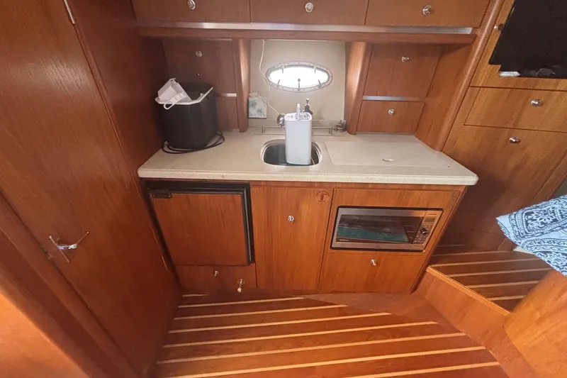 Slide: The Image of 2008 Tiara Yachts 3200 Open galley with wood cabinetry, sink, and appliances. - 16