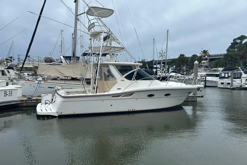 Slide: The Image of 2008 Tiara Yachts 3200 Open docked in a marina, surrounded by other boats. - 4