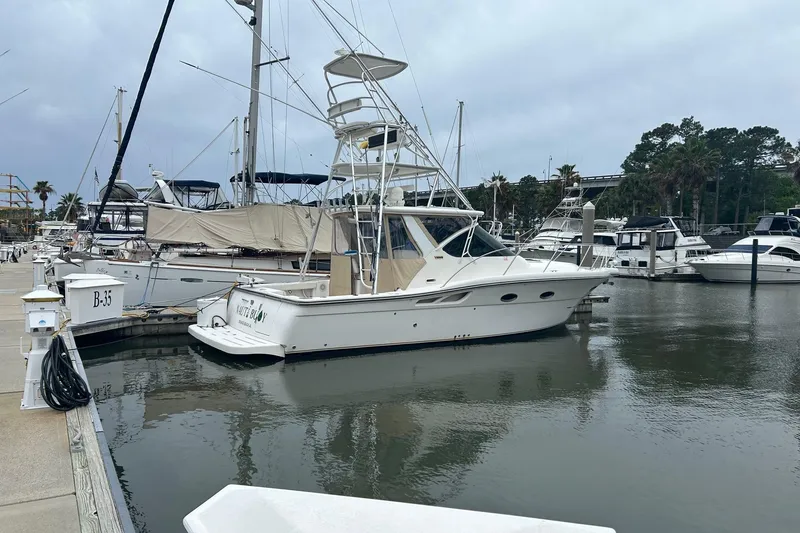 Slide: The Image of 2008 Tiara Yachts 3200 Open docked in a marina, surrounded by other boats. - 5