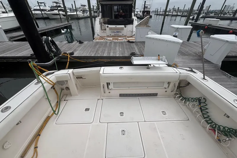 Slide: The Image of 2008 Tiara Yachts 3200 Open at marina, showcasing spacious deck and docked boats. - 9