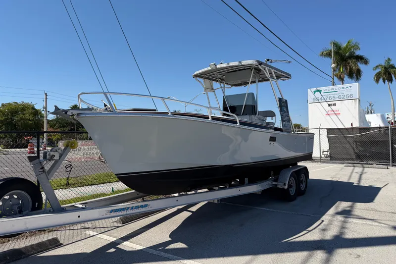The Image of 2020 Strike 26' Center Console Cuddy boat on trailer, parked outdoors under clear sky. - 0