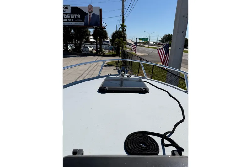 Slide: The Image of 2020 Strike 26' Center Console Cuddy boat deck with American flags in the background. - 16