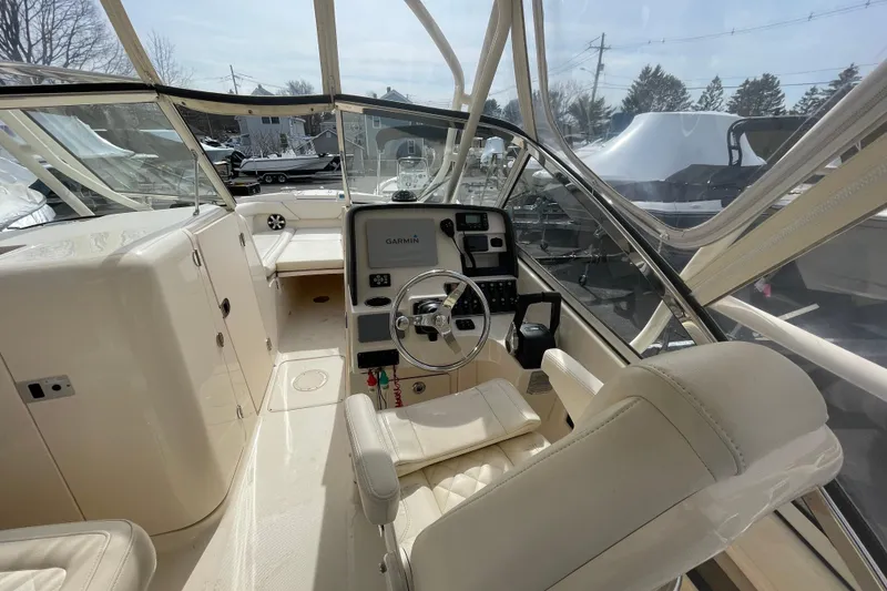 Slide: The Image of 2017 Grady-White Freedom 275 boat interior with steering wheel and navigation system. - 10