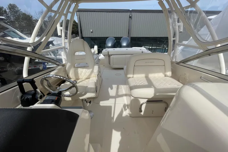 Slide: The Image of 2017 Grady-White Freedom 275 boat interior with seating and steering wheel. - 13