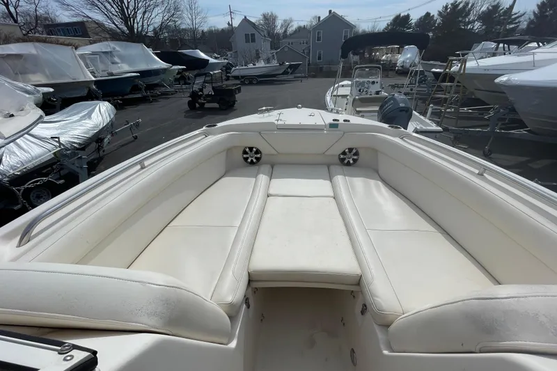 Slide: The Image of 2017 Grady-White Freedom 275 boat interior with white seating in a marina setting. - 14