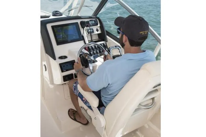 Slide: The Image of Manufacturer Provided Image: Man piloting 2017 Grady-White Freedom 275 boat, navigating with advanced controls. - 22