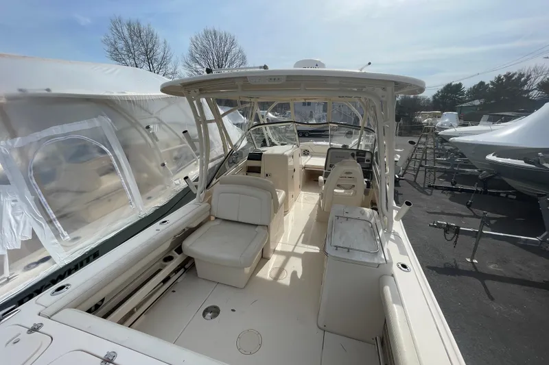 Slide: The Image of 2017 Grady-White Freedom 275 boat interior with seating and helm, parked outdoors. - 7