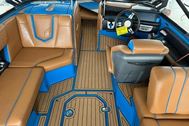 Slide: The Image of 2020 Nautique Super Air Nautique G25 interior with tan and blue seating, modern dashboard. - 17