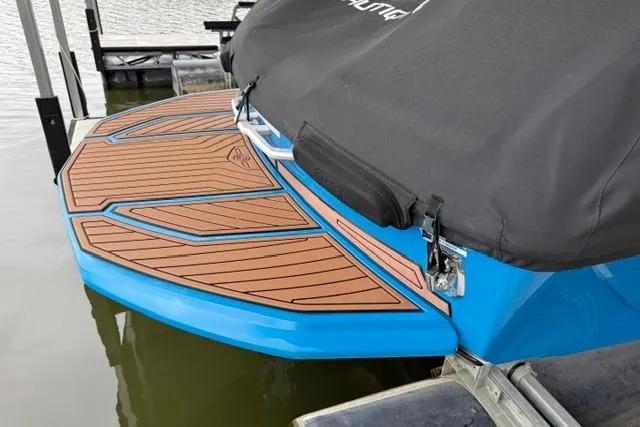 Slide: The Image of 2020 Nautique Super Air Nautique G25 with covered deck, docked on water. - 27