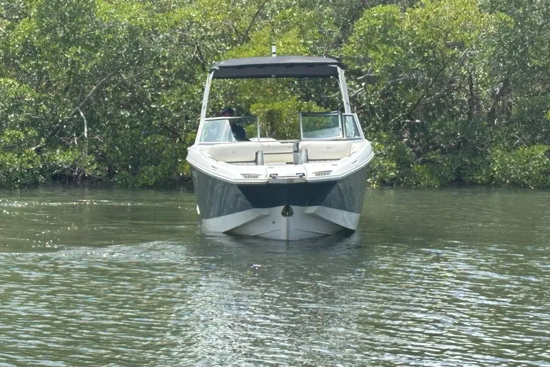 Slide: The Image of 2019 Cobalt 23SC boat on calm water, surrounded by lush greenery. - 4