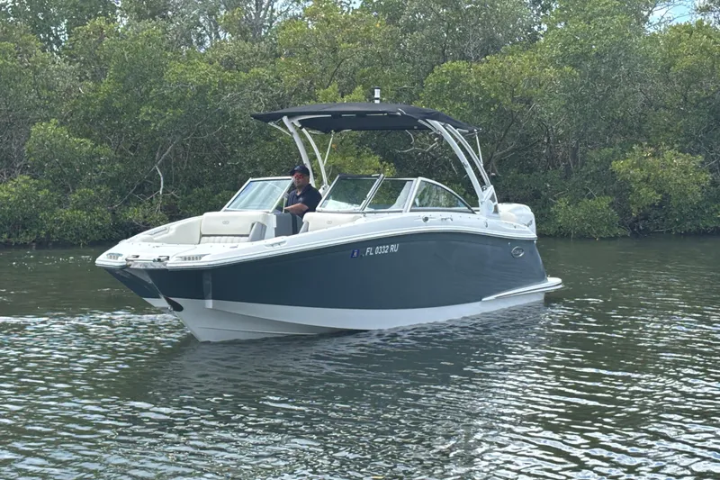 Slide: The Image of 2019 Cobalt 23SC boat cruising on a calm river with lush greenery. - 5