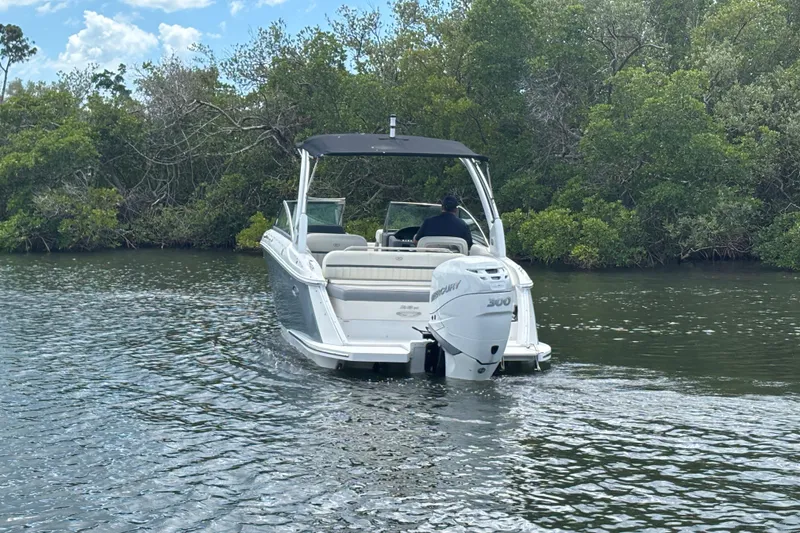 Slide: The Image of 2019 Cobalt 23SC boat cruising on a calm river with lush greenery. - 7