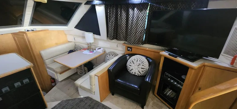 Slide: The Image of Interior of 1996 Carver 400 Cockpit Motor Yacht with seating, table, and entertainment area. - 16